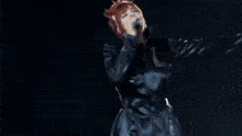 a woman with red hair is singing on a stage