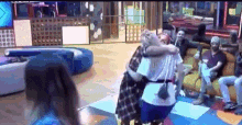 a group of people are hugging each other in a living room .
