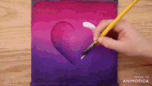 a person is painting a heart on a canvas with a yellow brush