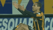 a soccer player wearing a yellow and black striped jersey with the number 10 on it