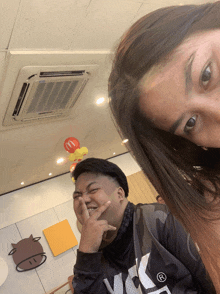 a man and a woman are posing for a picture in front of a mcdonald 's sign