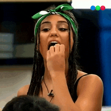 a woman with dreadlocks and a green bandana on her head