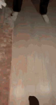 a person wearing white socks is walking on a wooden floor