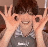 a young man wearing headphones is making a heart shape with his hands .