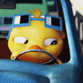 a yellow duck wearing blue sunglasses is driving a blue car