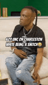 a man is sitting on a couch with the words 607 unc on charleston white being a snitch written above him