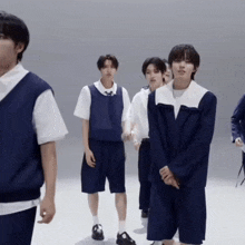 a group of young men are standing next to each other on a white surface .