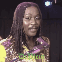 a man with dreadlocks singing into a microphone with the name dr. stein written in green