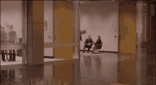 a group of people walking through a hallway with a yellow door