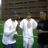 a man wearing a san francisco giants jersey stands on a field with two other men