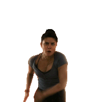 a woman in a gray shirt and black jeans is making a funny face