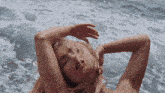 a naked woman is laying in the ocean with her head in the water