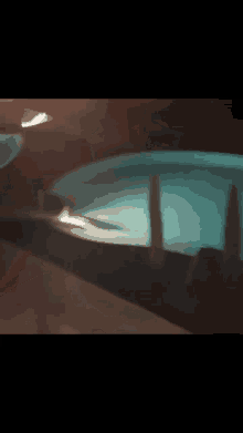 a person is standing in a pool at night