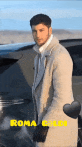 a man in a tan coat is standing in front of a car with the name roma goldi written on the bottom