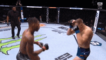 two men are fighting in a boxing ring with ufc on the corner