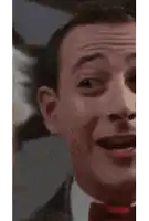 a close up of a man 's face with a red tie