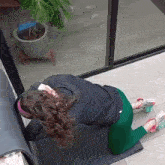 a woman is kneeling down on a yoga mat in front of a window