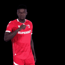 a man wearing a red shirt with superbet on the front