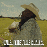 a man in a cowboy hat with the words when the time comes on the bottom