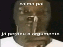 a man is holding a gun to his mouth and saying `` calma pai `` .