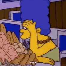 marge simpson from the simpsons is sitting at a table with a bunch of food on it .