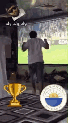 a man is dancing in front of a large screen while watching a soccer match .