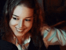 a woman with a nose ring is smiling while looking at a computer screen