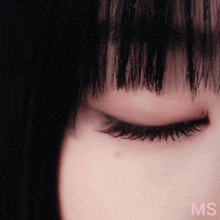 a close up of a woman 's eye with the letters ms in pink