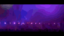 a crowd of people are watching a concert with purple lights