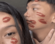 a man and a woman are kissing with red lipstick on their faces