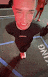 a man is standing on a trampoline with his head in the air and smiling .