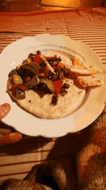 a person is holding a plate with a tortilla on it and a piece of bread