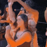 a group of women are dancing in a dark room