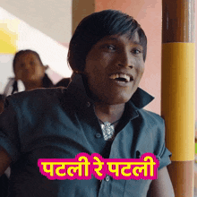 a man in a black shirt is smiling with a pink sticker that says patli