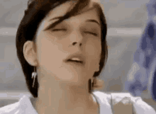 a close up of a woman with her eyes closed and her mouth open .