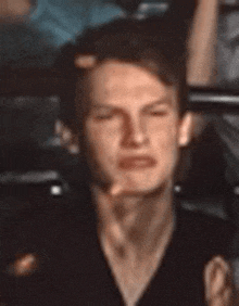 a close up of a man 's face with his eyes closed and his hand on his face .