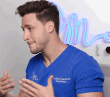 a man wearing a blue shirt that says dr. alfred timberski d.d. family medicine