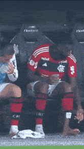two soccer players sit on a bench with one wearing a shirt that says flexform