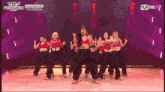 a group of women are dancing on a stage with mnet written on the bottom of the screen