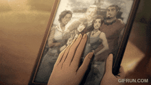 a hand is touching a picture of a group of people with the website gifrun.com in the corner
