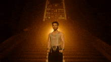 a man with a beard is wearing a gold tank top and a necklace