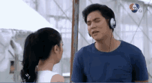 a man is wearing headphones and talking to a woman .