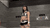 a woman in a stardom outfit stands in front of a sign that says a