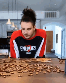 a man wearing a sweatshirt that says enemies forever