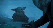 a baby yoda is sitting in the snow with the words [ whines ] written above it