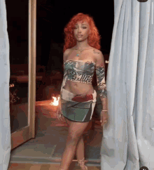 a woman with red hair is standing in front of a window wearing a crop top and skirt