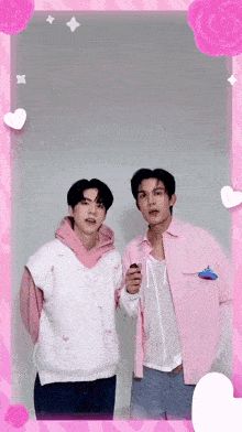 two men are standing next to each other in a pink and white photo frame