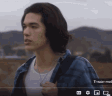 a man in a denim jacket and white tank top is shown on a screen that says theater mode