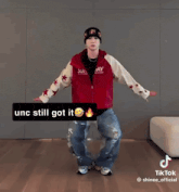 a man wearing a red jacket and a beanie is dancing on a tiktok video .