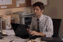 a man sitting at a desk with a dell laptop